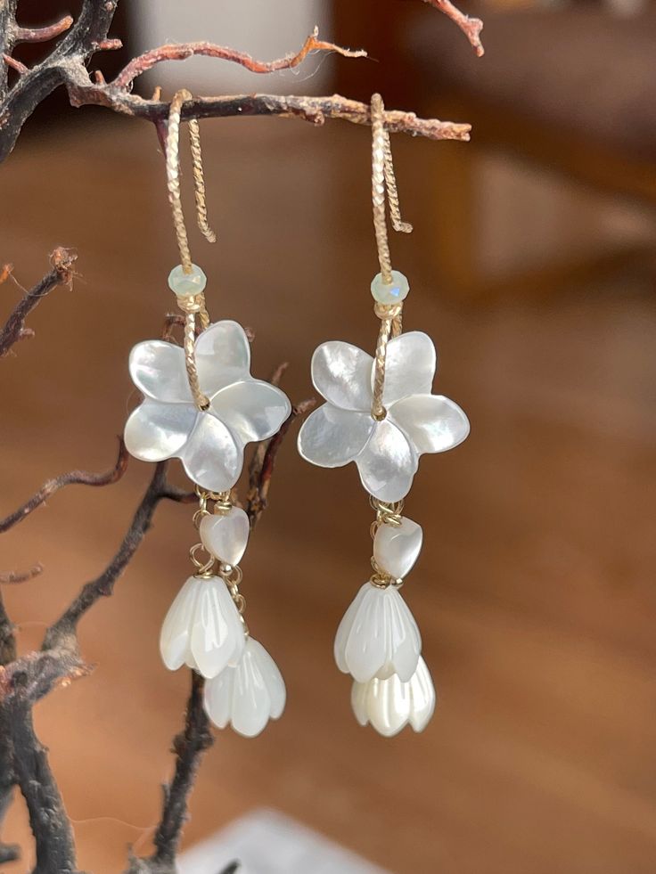 "Hawaiian Plumeria Pikake Mother of Pearl 14K Gold Filled or Silver Earrings Happy Spring Cherry Blossom time! In Hawaii we have the White Plumeria Pikake's that are so Kawaii (cute)! These Natural White Mother of Pearl Plumeria and Pikake earrings and are high quality and highly light reflective when you move it around. Material: Mother of Pearl Plumeria, Pikake, and 1 Tiny heart. 14K Gold Filled sparkle wire handmade ear hook with mini hoop & small cable chain. Also available in 925 Sterling S Whimsical White Flower Shaped Earrings, Whimsical White Flower-shaped Earrings, Whimsical White Flower Earrings, Charming White Dangle Jewelry, Whimsical Gold Flower-shaped Earrings, Hawaiian Earrings, White Plumeria, So Kawaii, Hawaiian Plumeria