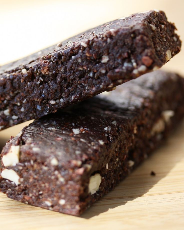 two pieces of brownie sitting on top of a wooden cutting board next to each other