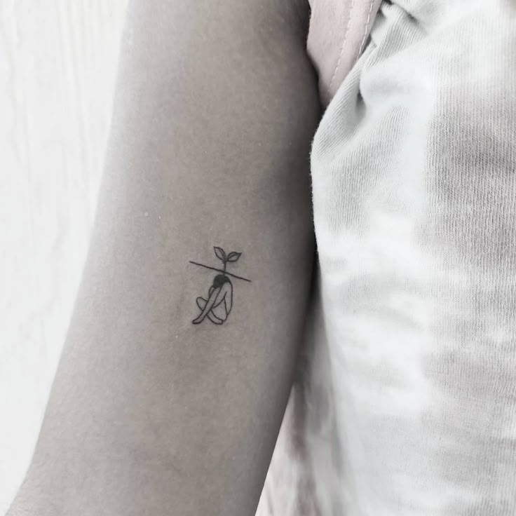 a woman's arm with a small tattoo on the left side of her arm