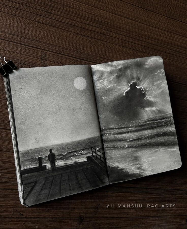 an open book on a wooden table with a person looking out at the ocean in black and white