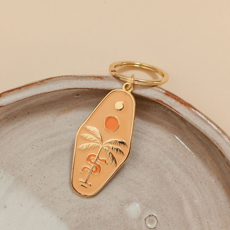 a gold keychain with a palm tree on it