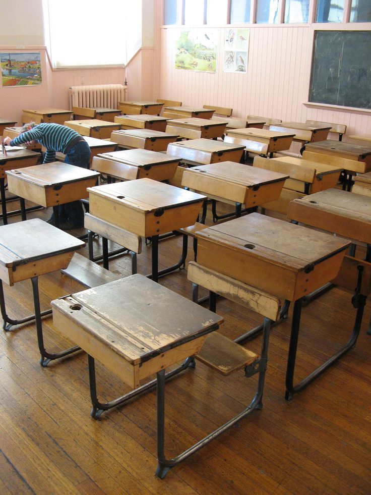 an empty classroom filled with wooden desks