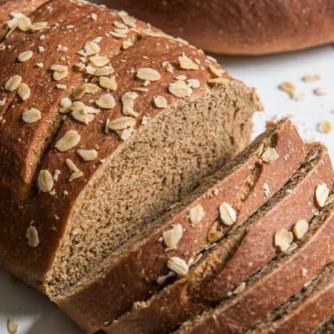 two loaves of bread sitting on top of a white plate next to each other