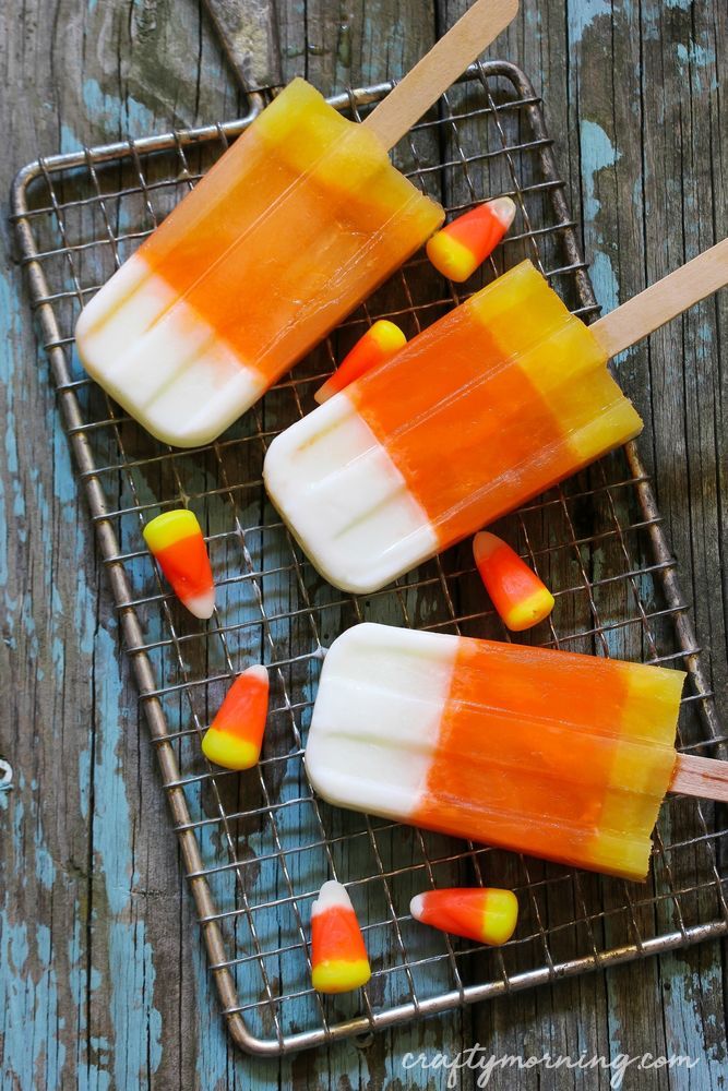 three popsicles on a cooling rack with candy corn