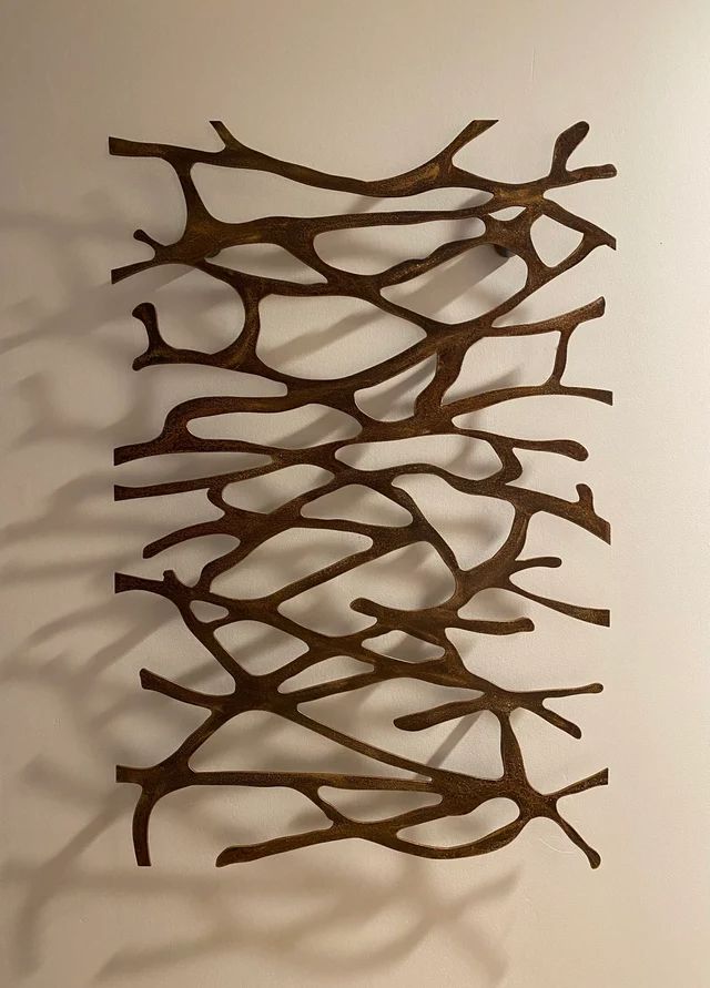 a metal sculpture is hanging on the wall