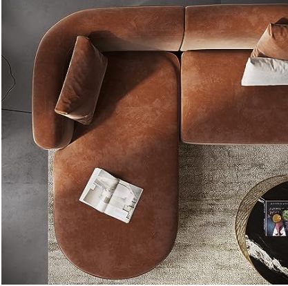 a brown couch sitting on top of a wooden table