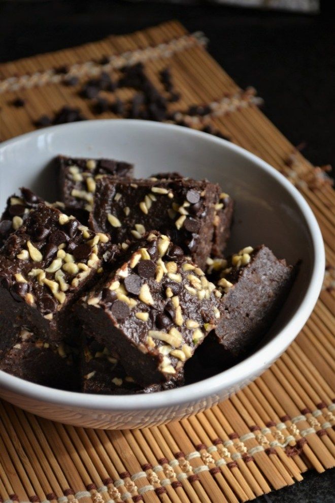 some brownies are in a white bowl on a mat