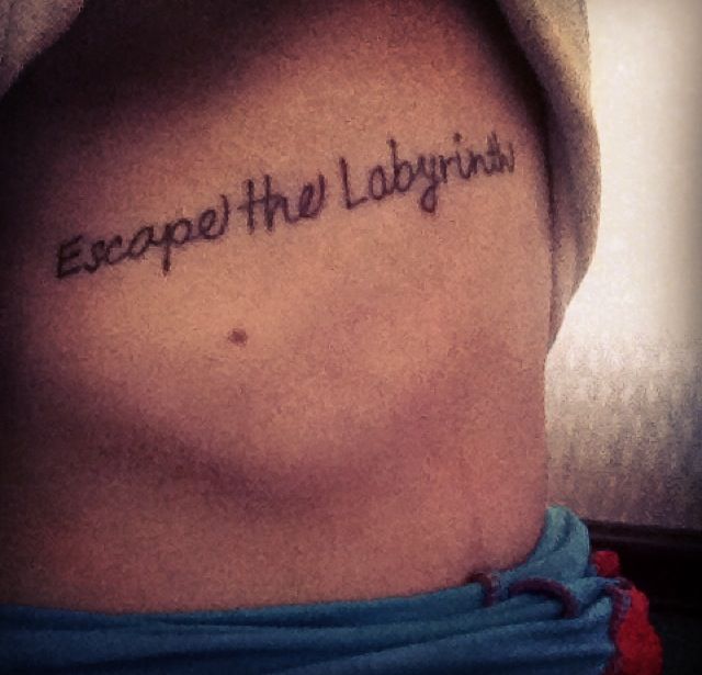 a man's chest with the words escape the laughings written in cursive font