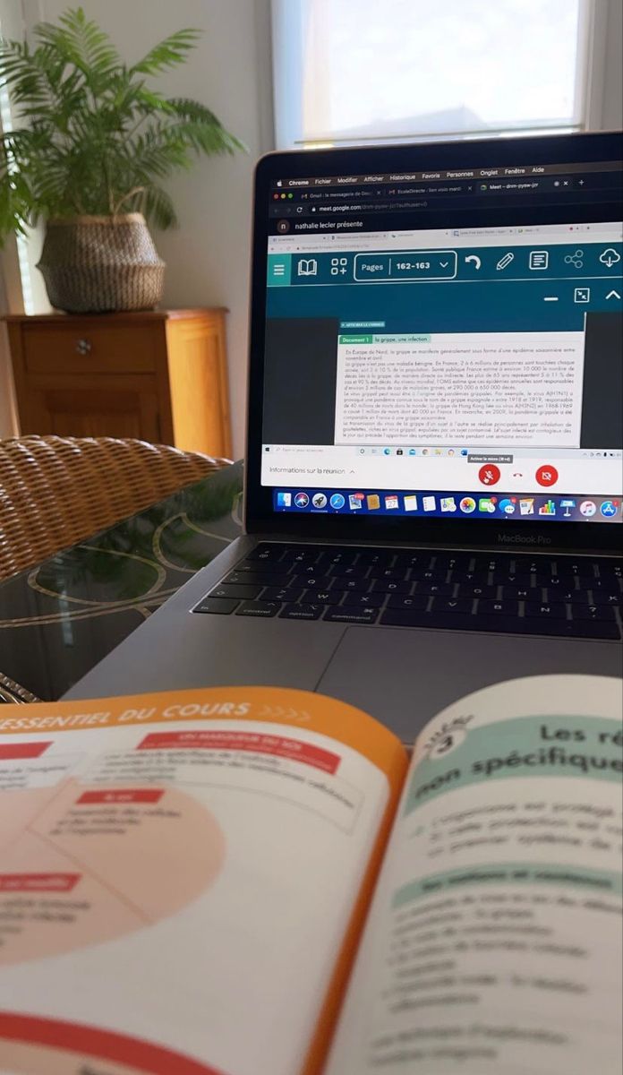 an open book sitting on top of a laptop computer