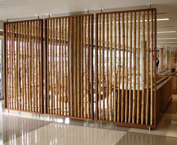 a room divider made out of bamboo sticks and wood slats in an office lobby