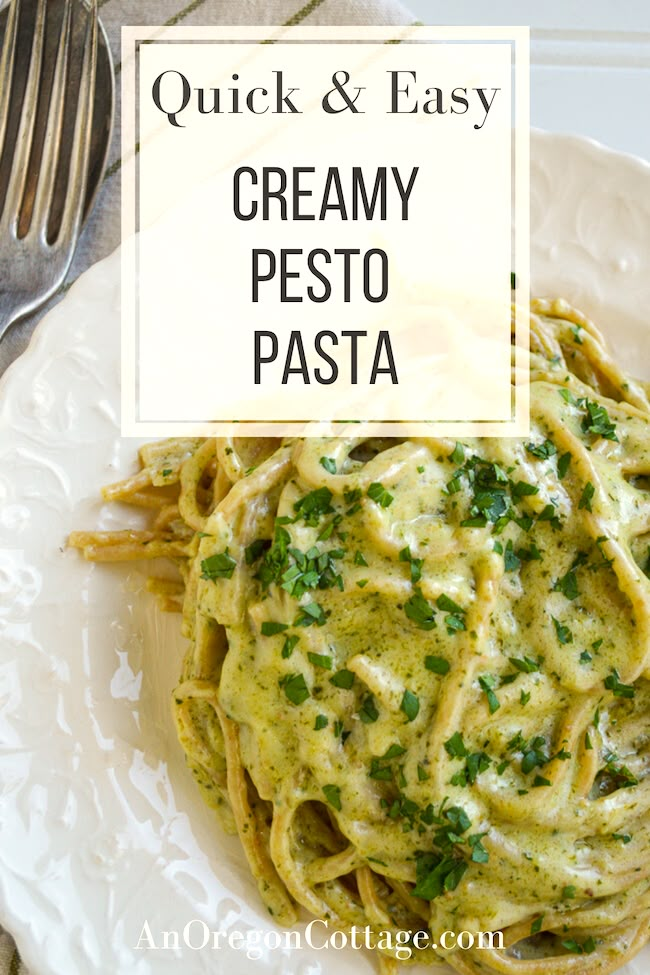 a white plate topped with pasta covered in pesto sauce