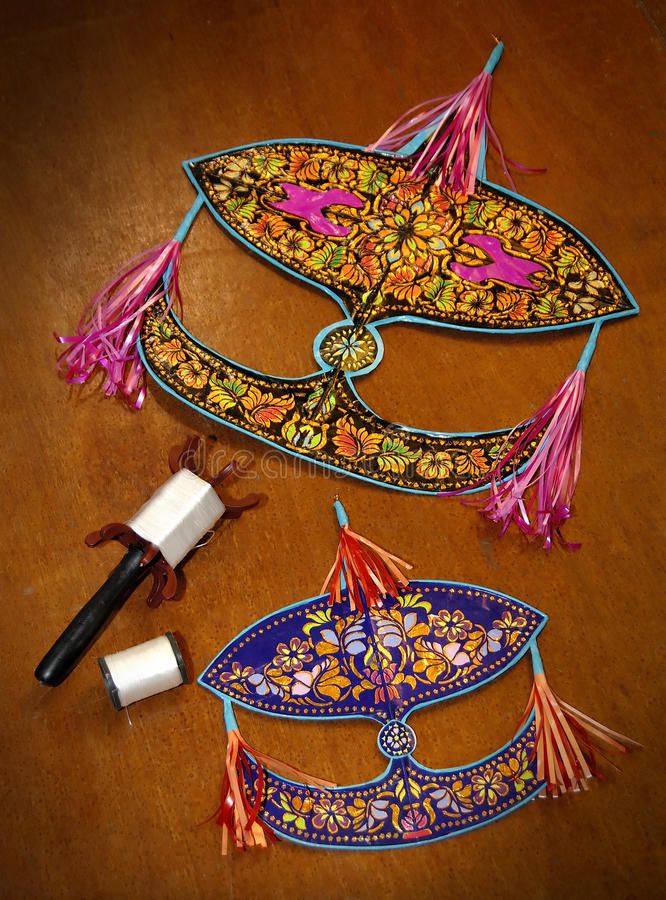 two masks with tassels on a wooden table