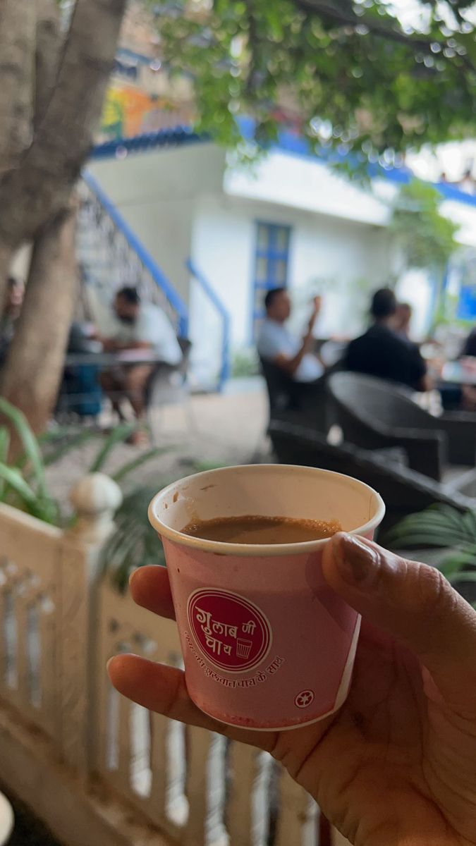 a person holding up a cup of coffee