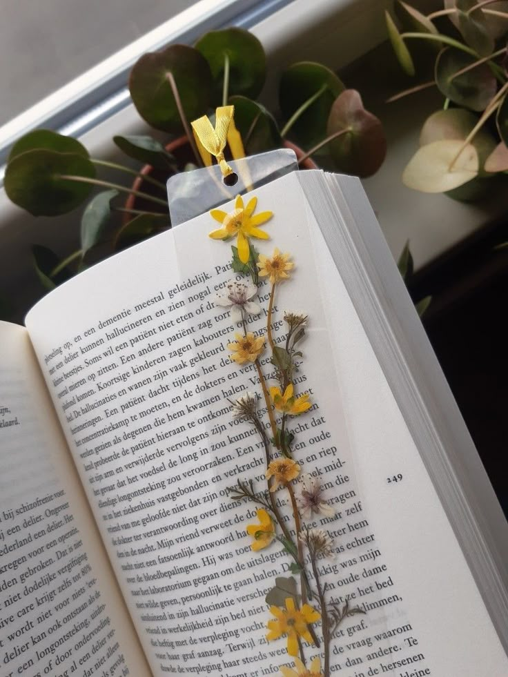 an open book with yellow flowers on it