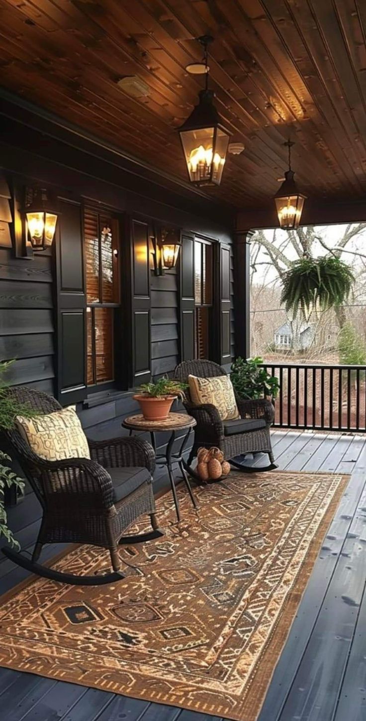 a porch with two chairs and a rug on the floor next to an outdoor table