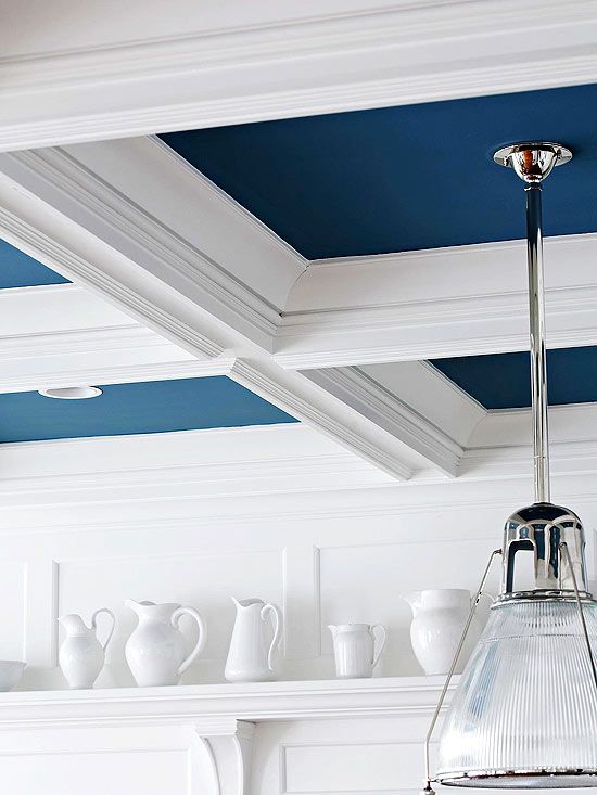 a kitchen with blue painted ceiling and white cabinets