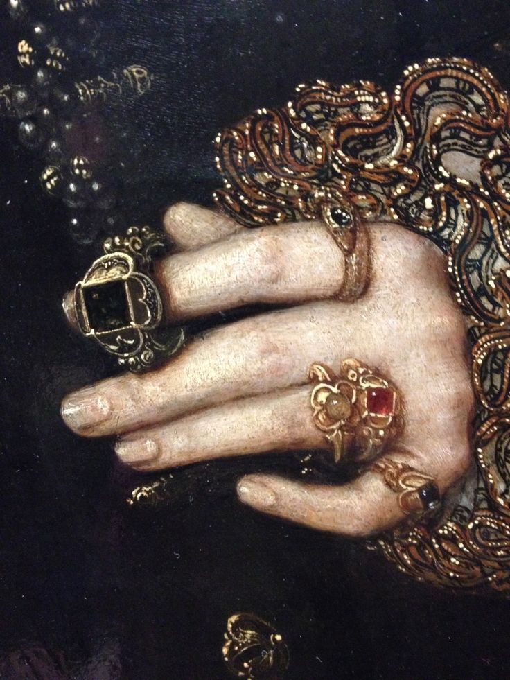 a close up of a person's hand with rings on it