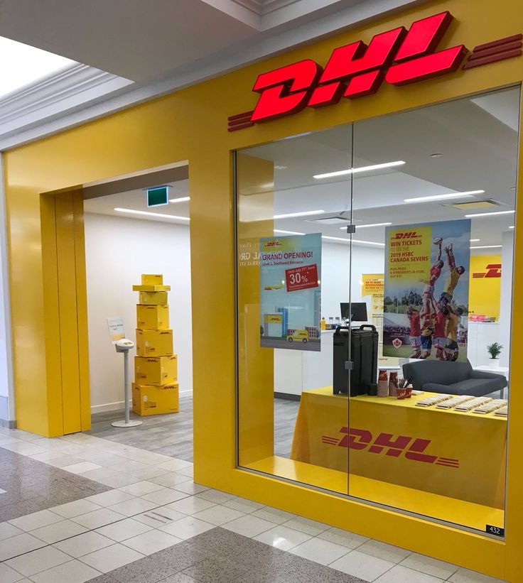 a yellow store front with the logo dhl on it's glass window display