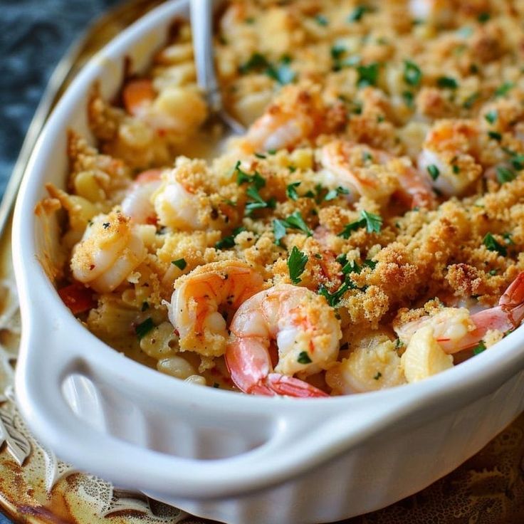 a casserole dish with shrimp and bread crumbs in it on a plate