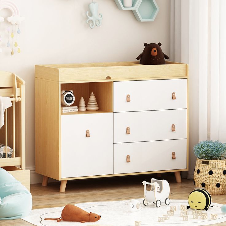 a baby's room with a crib, dresser and toys in the corner