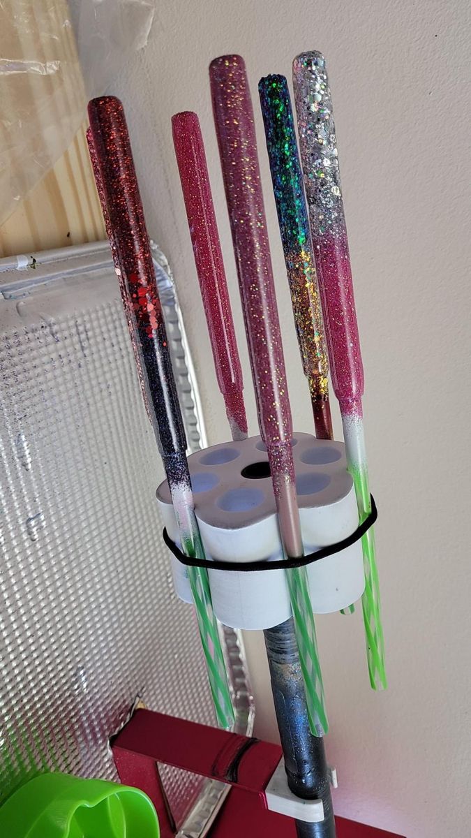 there are many different colored toothbrushes in the holder on the shelf next to each other