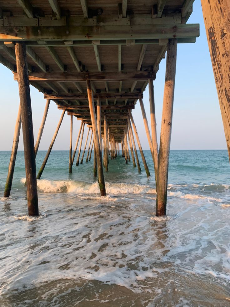 the underside of a pier with waves coming in