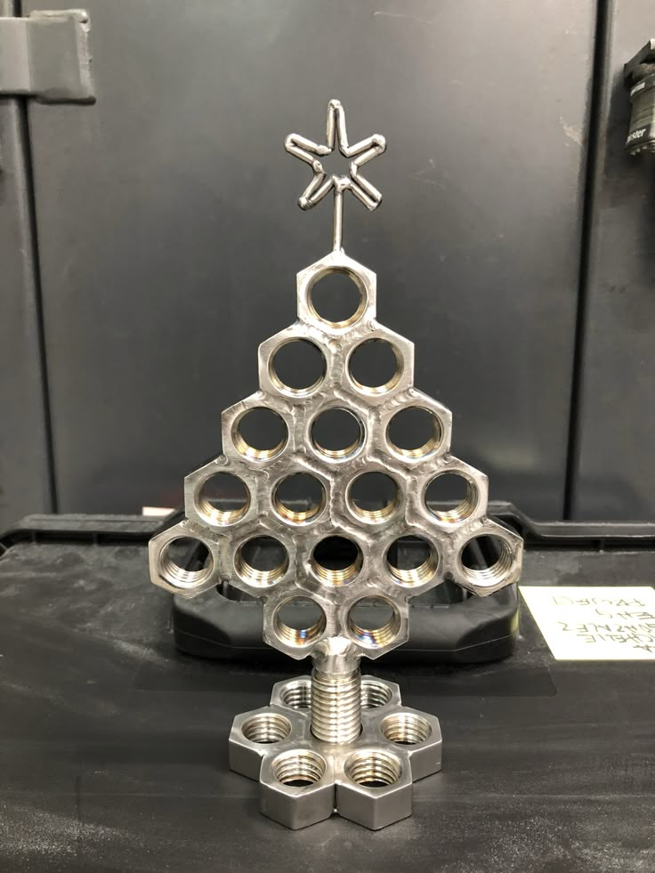 a metal christmas tree made out of nuts