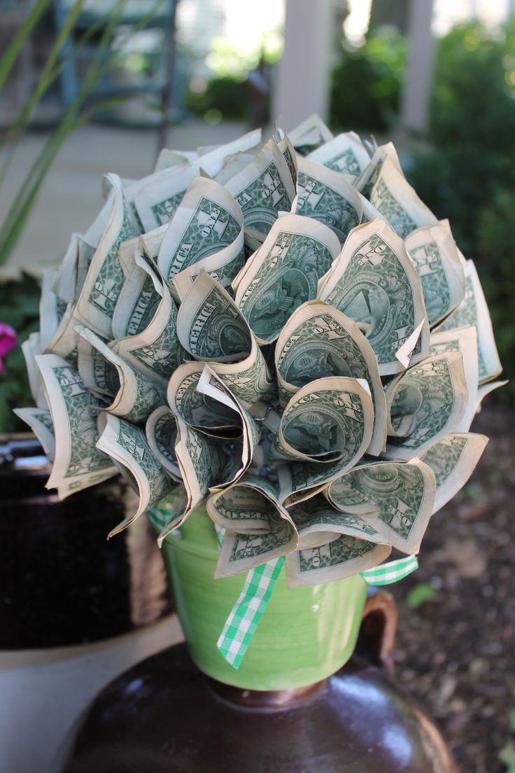 a vase filled with money sitting on top of a table