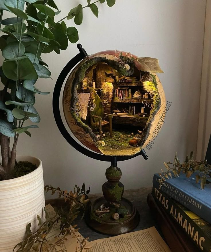 there is a small globe on top of a table next to a potted plant