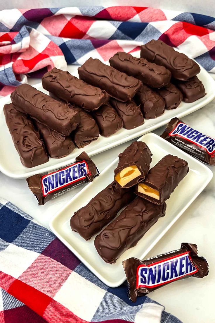 three plates filled with chocolate candy on top of a checkered table cloth