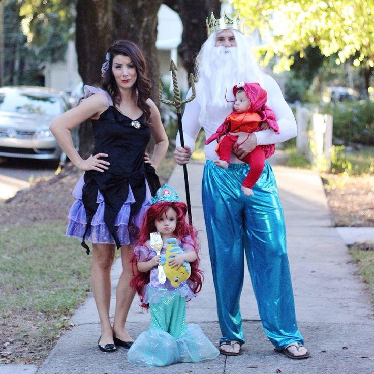 two women and a child dressed up as little mermaids, one holding a doll