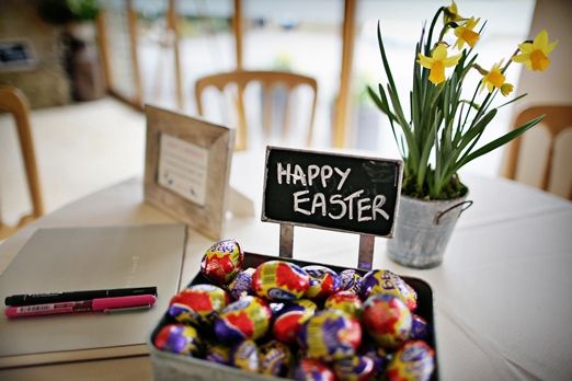 there is a sign that says happy easter next to some chocolate eggs on the table