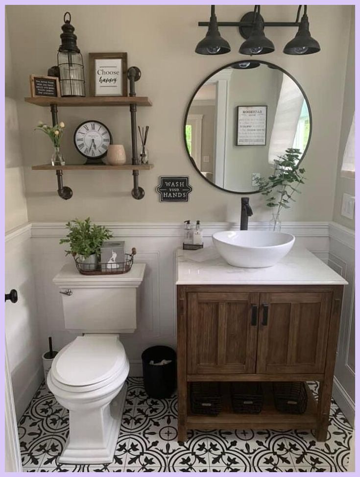 a white toilet sitting next to a bathroom sink under a round mirror on a wall