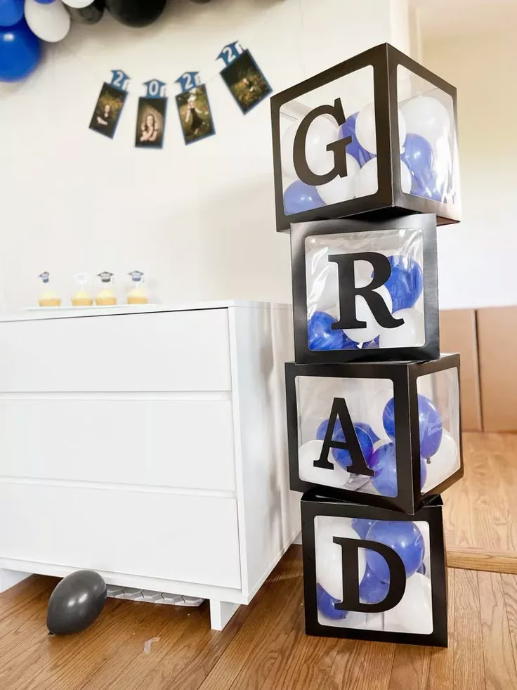 the blocks are stacked up with letters and balloons in the background, along with a chest of drawers