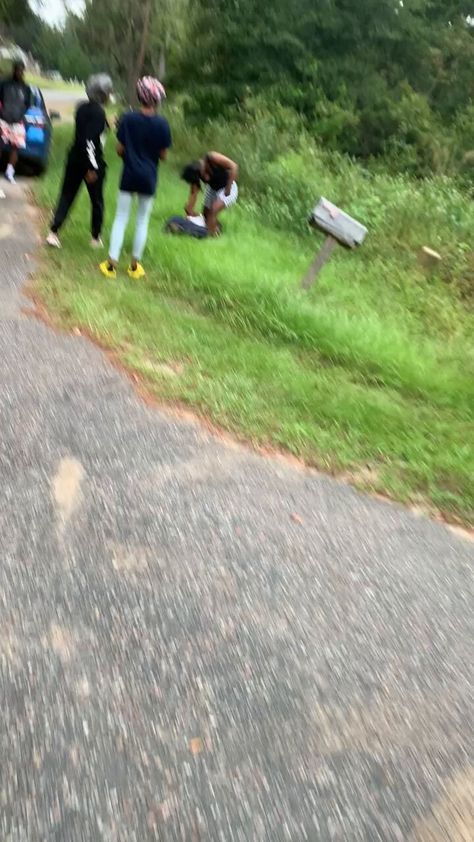 a group of people standing on the side of a road