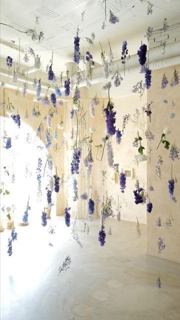 an art installation with flowers hanging from the ceiling