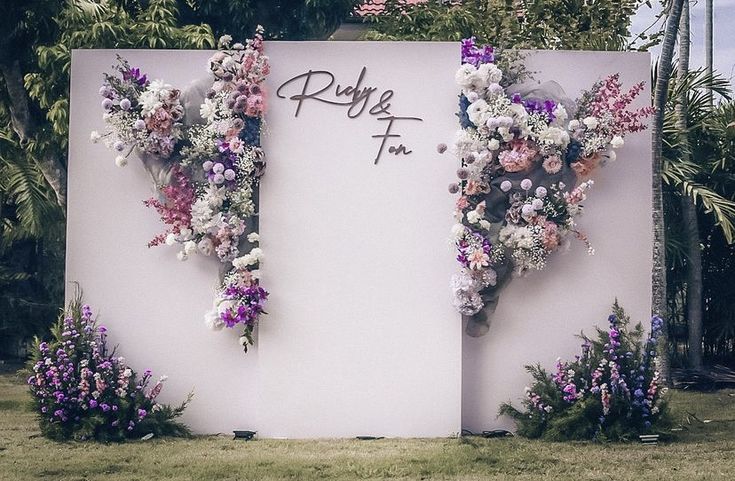 flowers are arranged on the side of a large sign that reads, rhyfe f