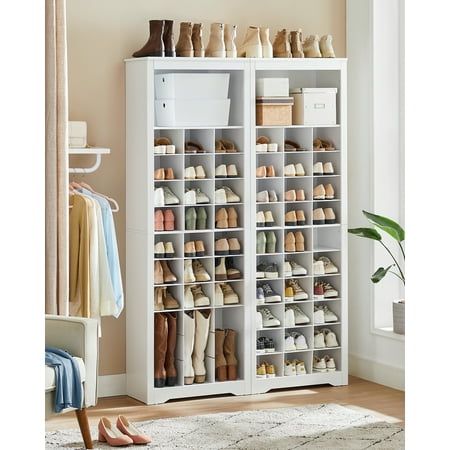 a large white shoe rack filled with lots of shoes next to a chair and rug