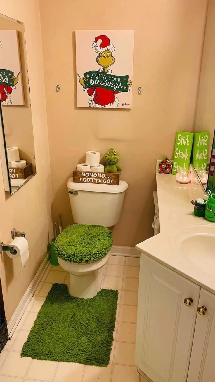 a bathroom with a toilet, sink and green rugs on the floor in front of it