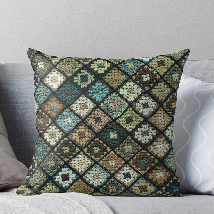 a decorative pillow on a couch with pillows and throw pillows in the shape of squares