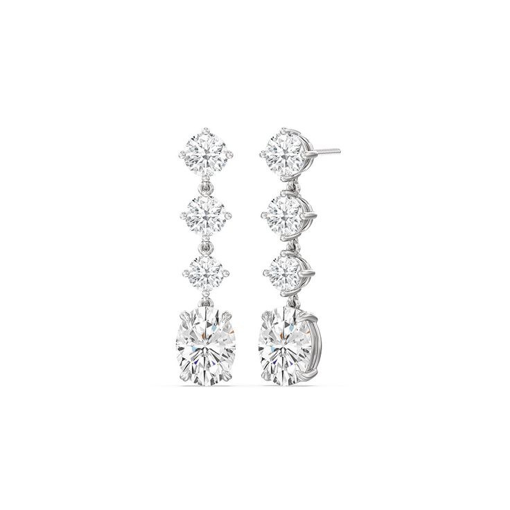 These diamond danglers exude a sense of sophistication and ease. They look relaxed and refined at once with their linear design and subtle movement. Each earring features a trio of round diamonds set in a vertical row and punctuated by a larger oval-cut diamond at the end. This elegant pair is the perfect choice when you want to dress to impress yet still be comfortable. Luxury Elegant Oval Huggie Earrings, Luxury Timeless Oval Diamond Earrings, Luxury Diamond Oval Huggie Earrings, Luxury Modern Oval Huggie Earrings, Luxury Oval Pendant Earrings As Gift, Diamond Danglers, Round Diamond Setting, Dangler Earrings, Linear Design