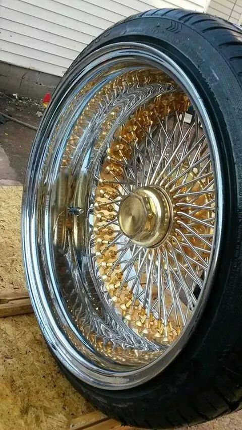 a close up of a motorcycle tire on the ground next to a garage door and window