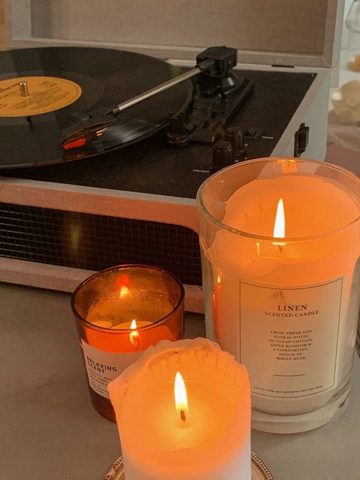 two candles sitting next to an old record player