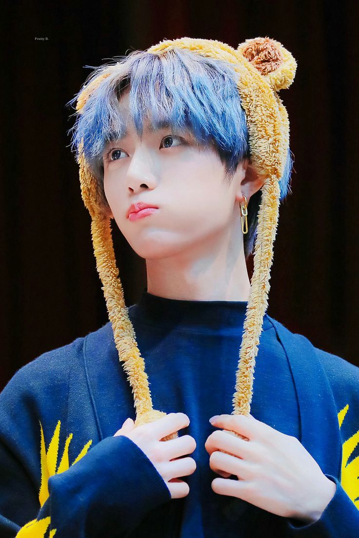 a boy with blue hair wearing a bear ears hat on top of his head and looking off to the side