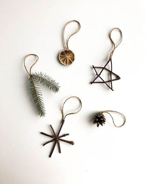 three ornaments hanging from twine with pine cones