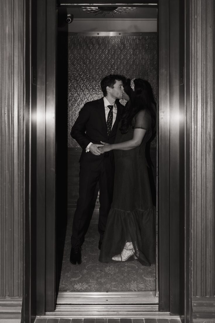 a man and woman kissing in an elevator