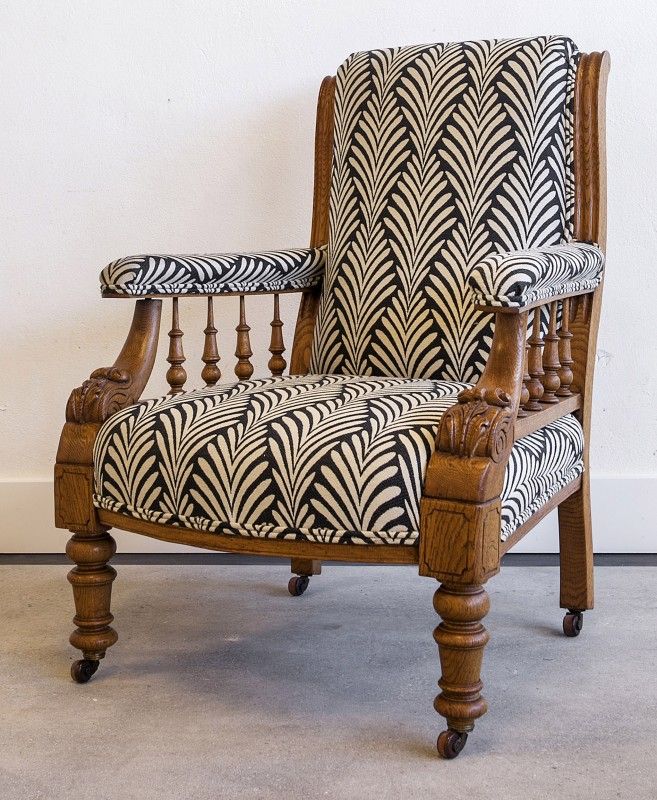 an old chair with zebra print upholstered on the back and armrests