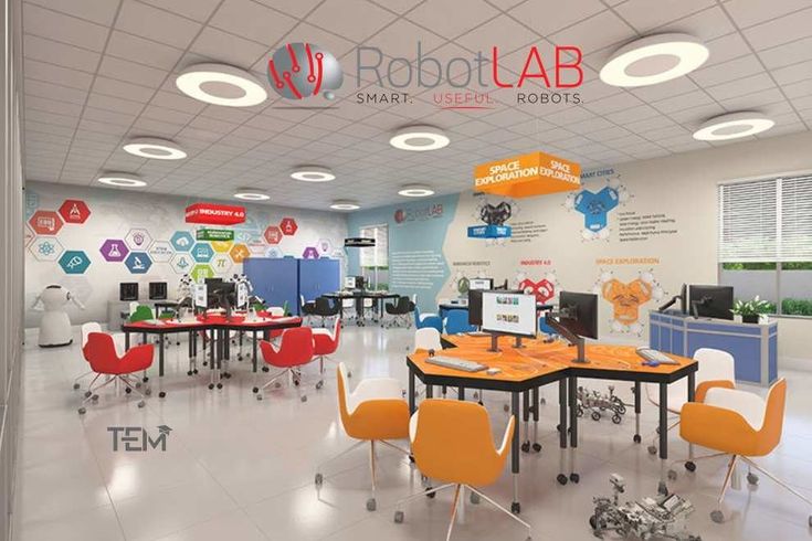 an office filled with lots of desks and chairs next to each other in front of a sign that says robot lab