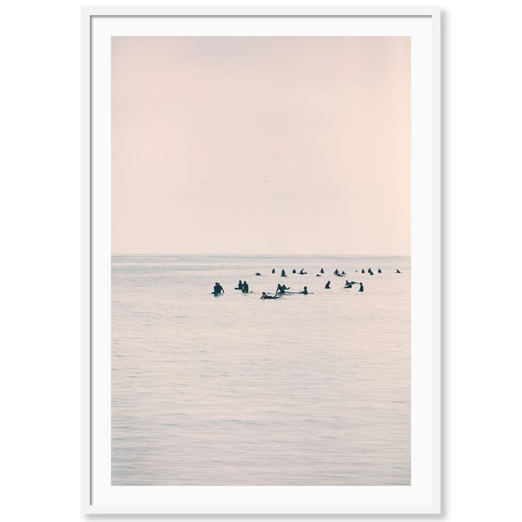 a group of people on small boats in the ocean at sunset or dawn, with birds flying overhead