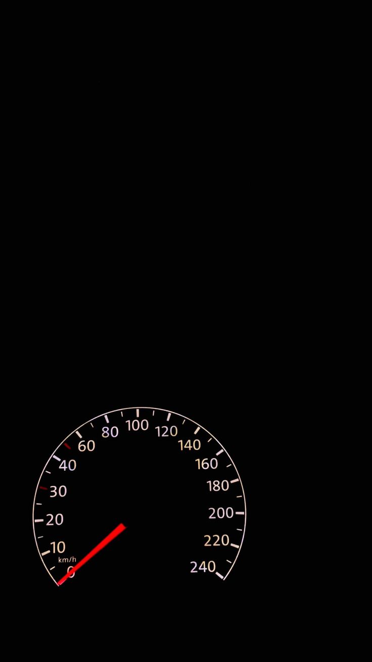 the speedometer is lit up in the dark with red arrow pointing to the left